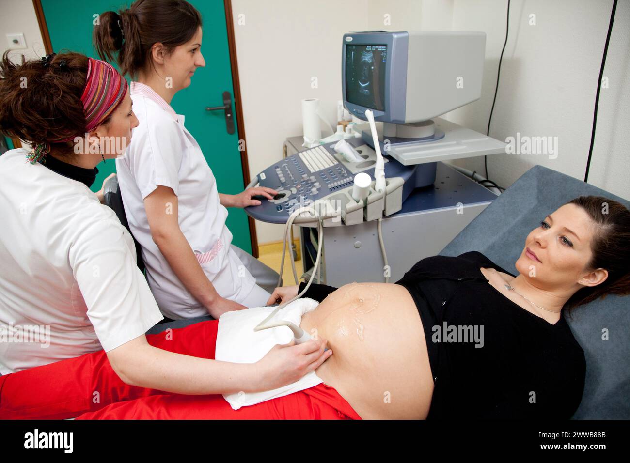 Hôpital. Maternité. étudiante sage-femme de 4e année réalisant une échographie prénatale sous la supervision d'une sage-femme. 24 semaines, 6 mois femme enceinte. Banque D'Images