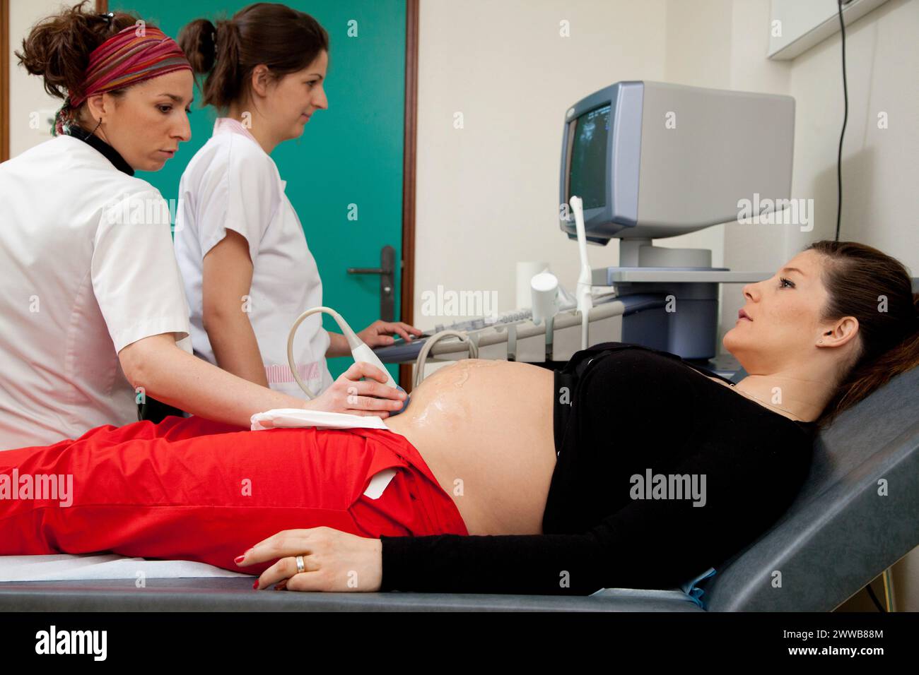 Hôpital. Maternité. étudiante sage-femme de 4e année réalisant une échographie prénatale sous la supervision d'une sage-femme. 24 semaines, 6 mois femme enceinte. Banque D'Images