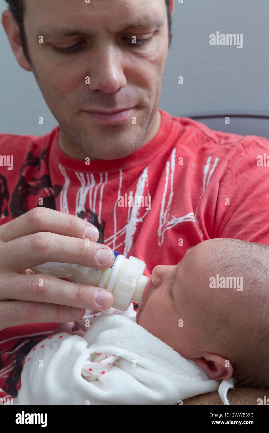 Père donnant le biberon à son enfant à la maternité. Banque D'Images