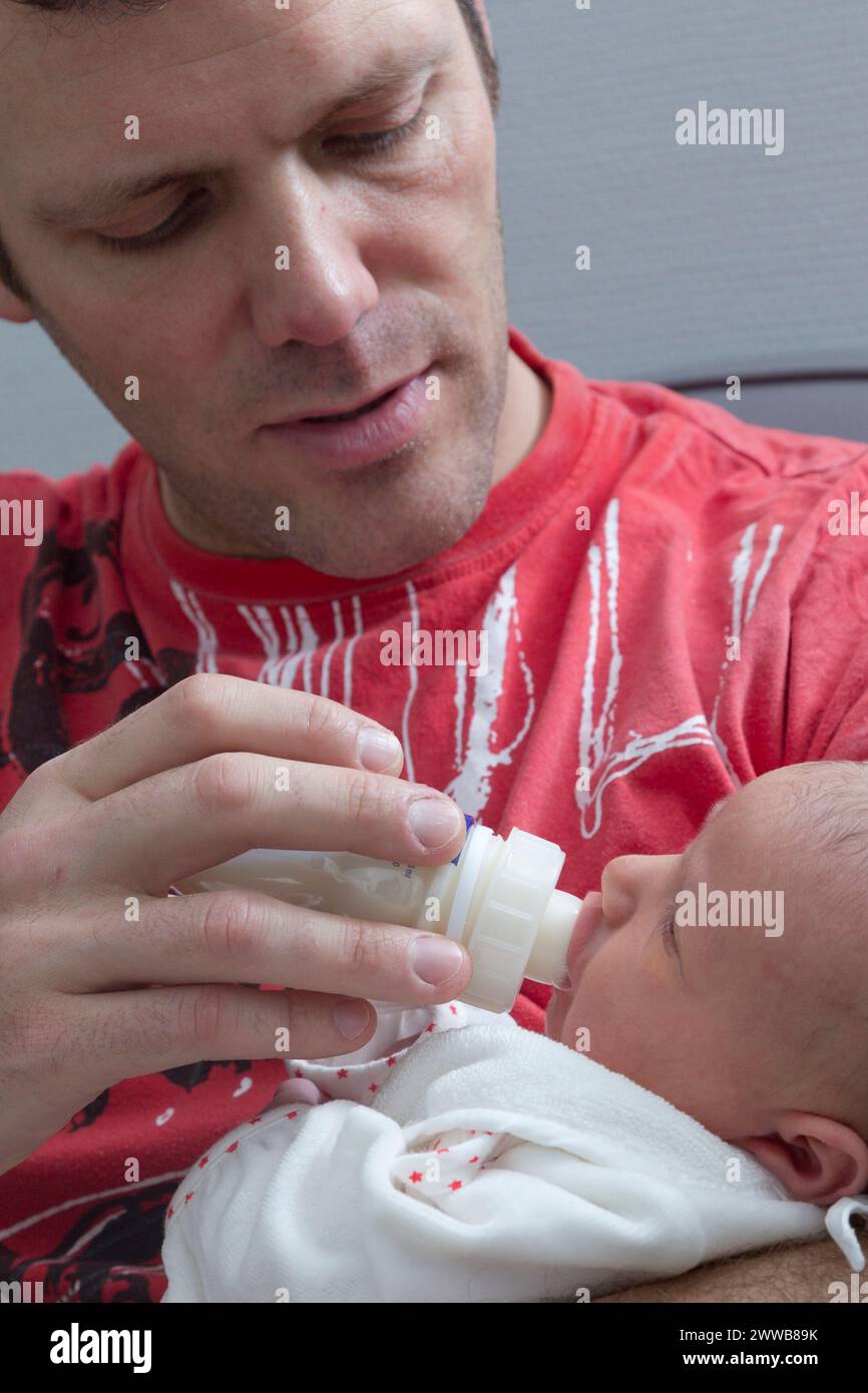 Père donnant le biberon à son enfant à la maternité. Banque D'Images