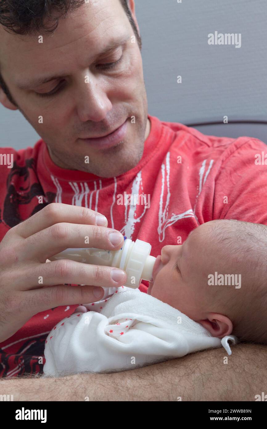 Père donnant le biberon à son enfant à la maternité. Banque D'Images