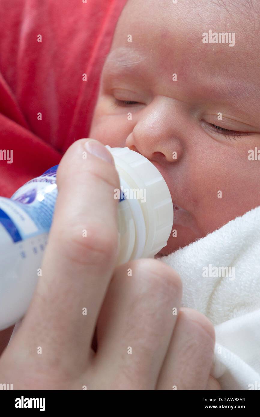 Père donnant le biberon à son enfant à la maternité. Banque D'Images