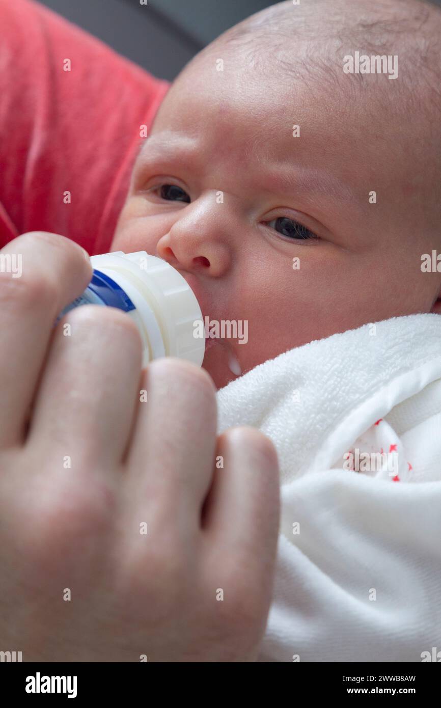 Père donnant le biberon à son enfant à la maternité. Banque D'Images