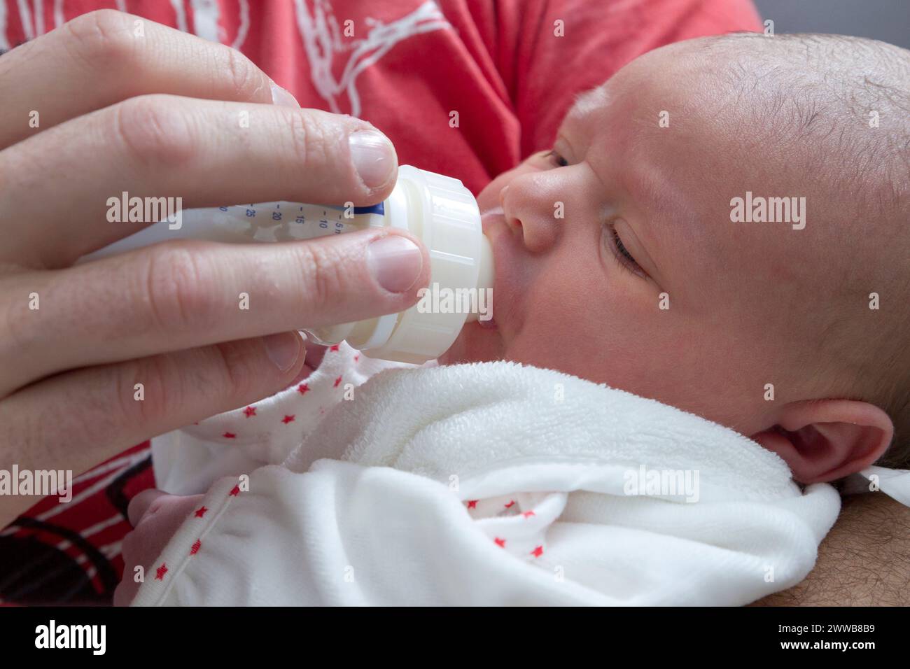 Père donnant le biberon à son enfant à la maternité. Banque D'Images