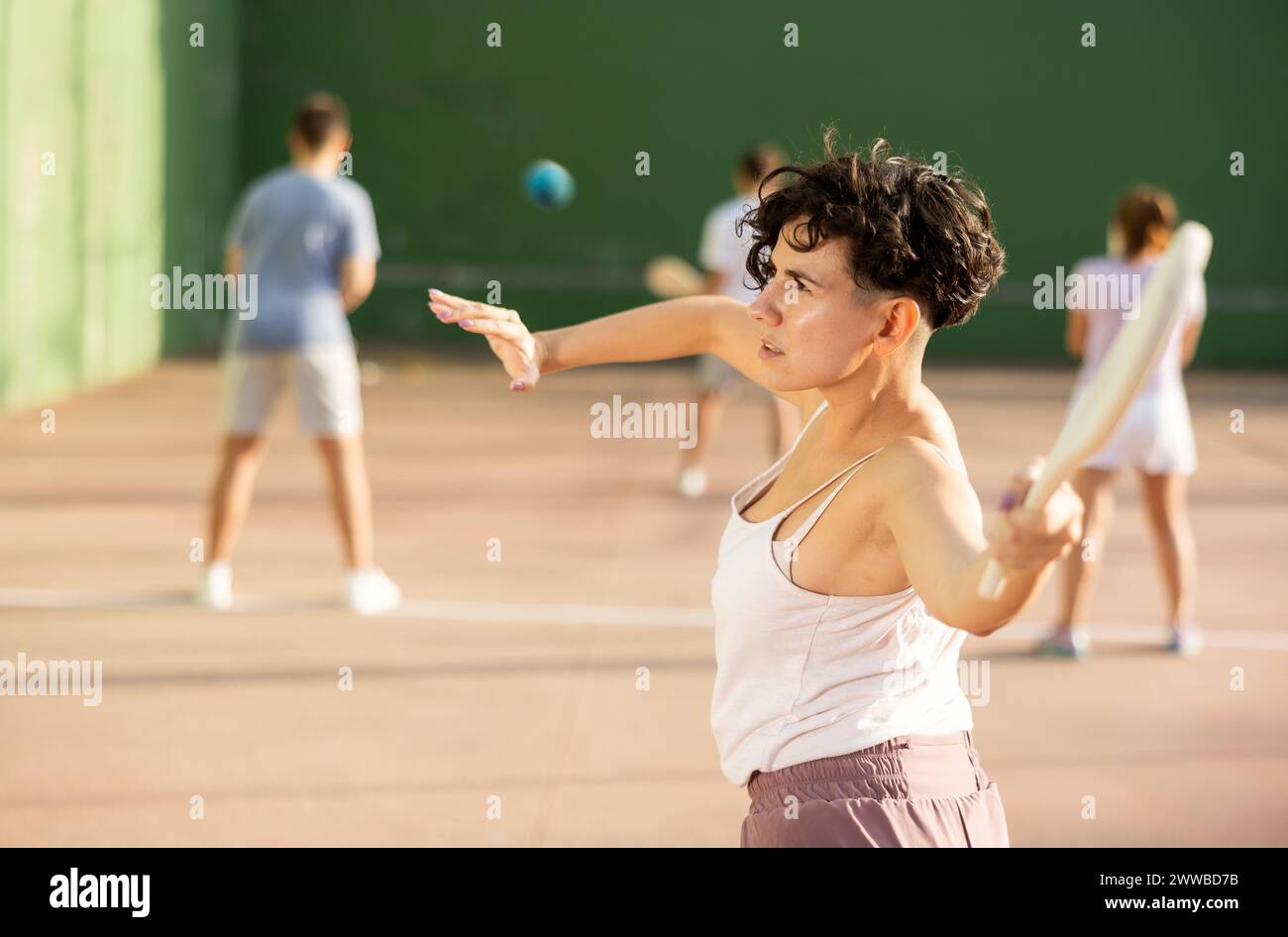Portrait d'une fille sportive jouant paleta fronton sur un terrain extérieur, prêt à frapper le ballon. Concept de mode de vie sain et actif Banque D'Images