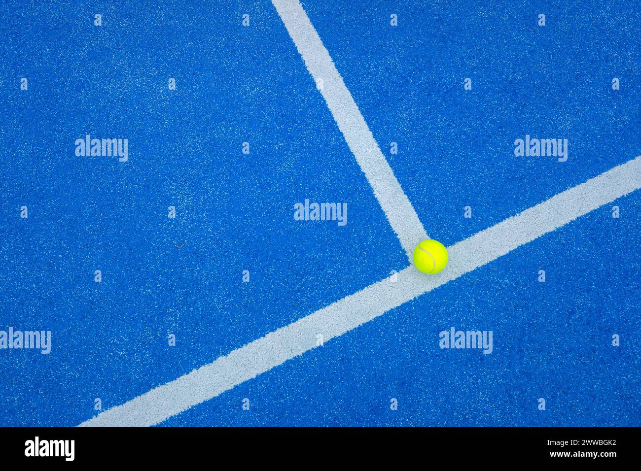 balle sur la ligne de base d'un court de paddle-tennis bleu Banque D'Images