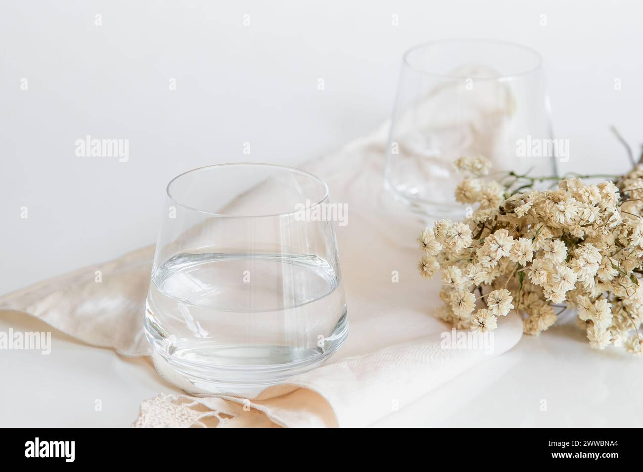 Tasse en verre contenant de l'eau naturelle sur fond blanc. Image simple et propre. Concept de simplicité de l'eau potable. Banque D'Images