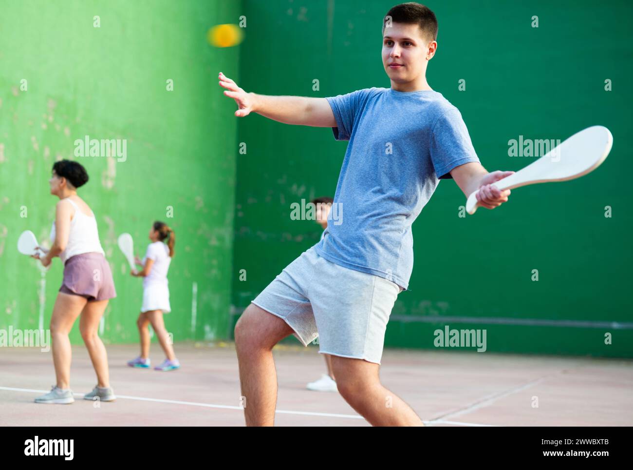 Jeune homme jouant pelota basque sur un terrain de pelota extérieur Banque D'Images