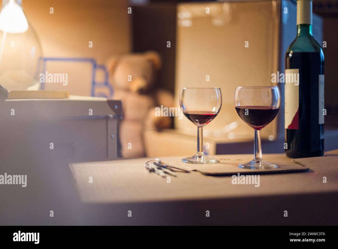 Bouteille de vin et verres sur boîte en carton dans une nouvelle maison Banque D'Images