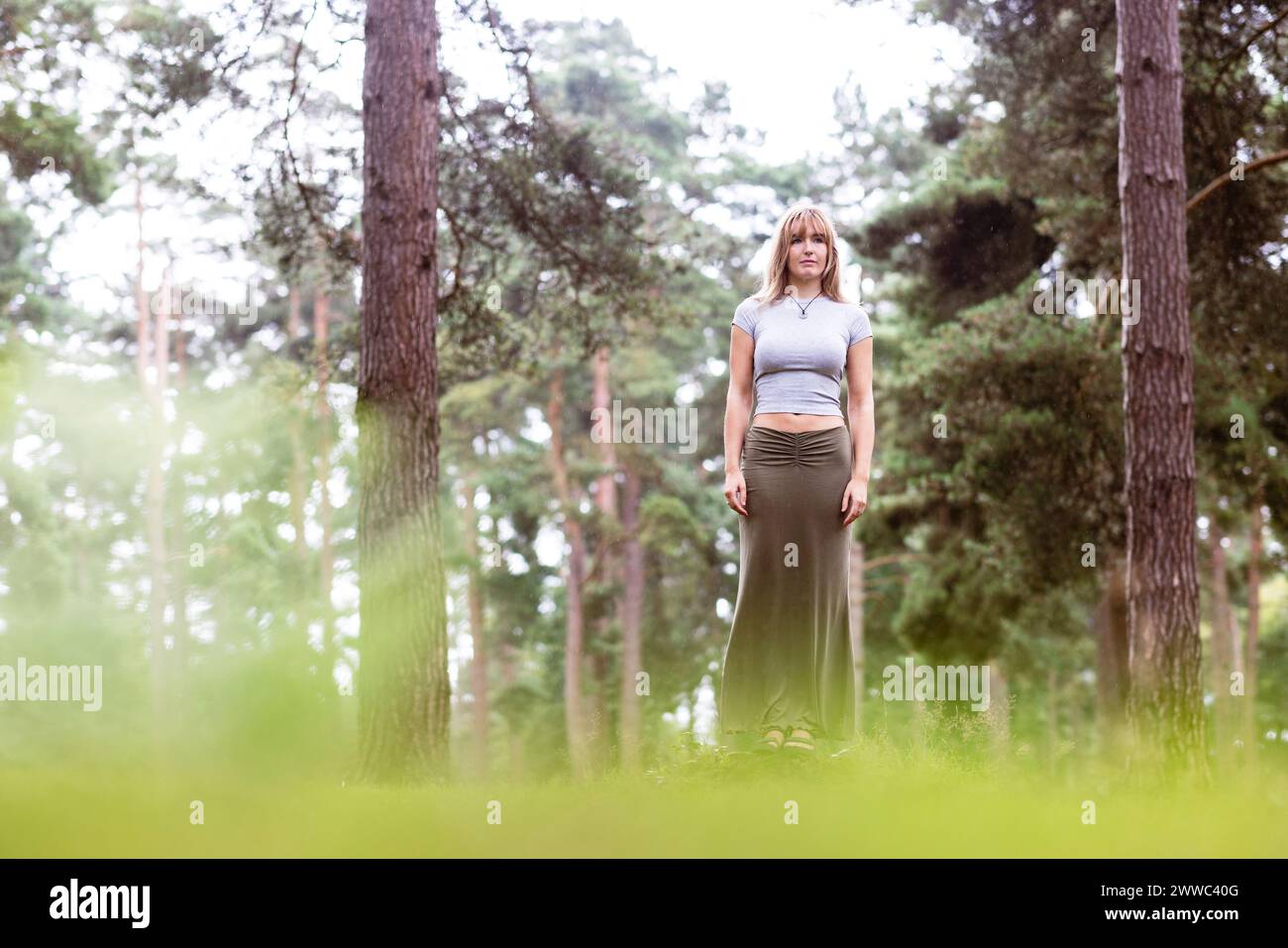 Jeune femme debout devant des arbres Banque D'Images