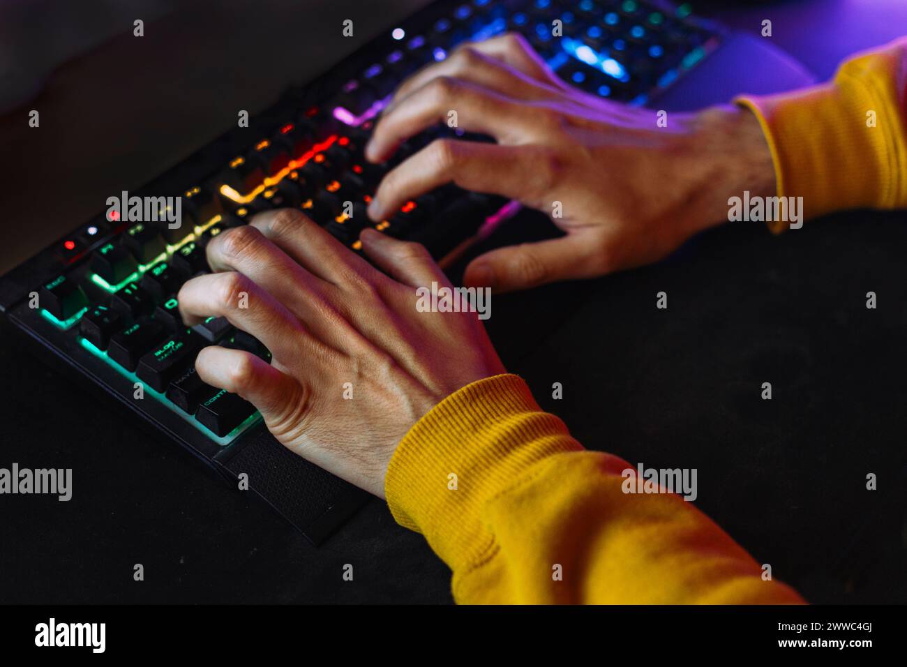 Mains de l'homme tapant sur le clavier lumineux Banque D'Images