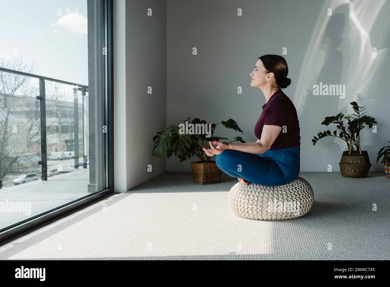 Femme méditant sur le siège à la maison Banque D'Images