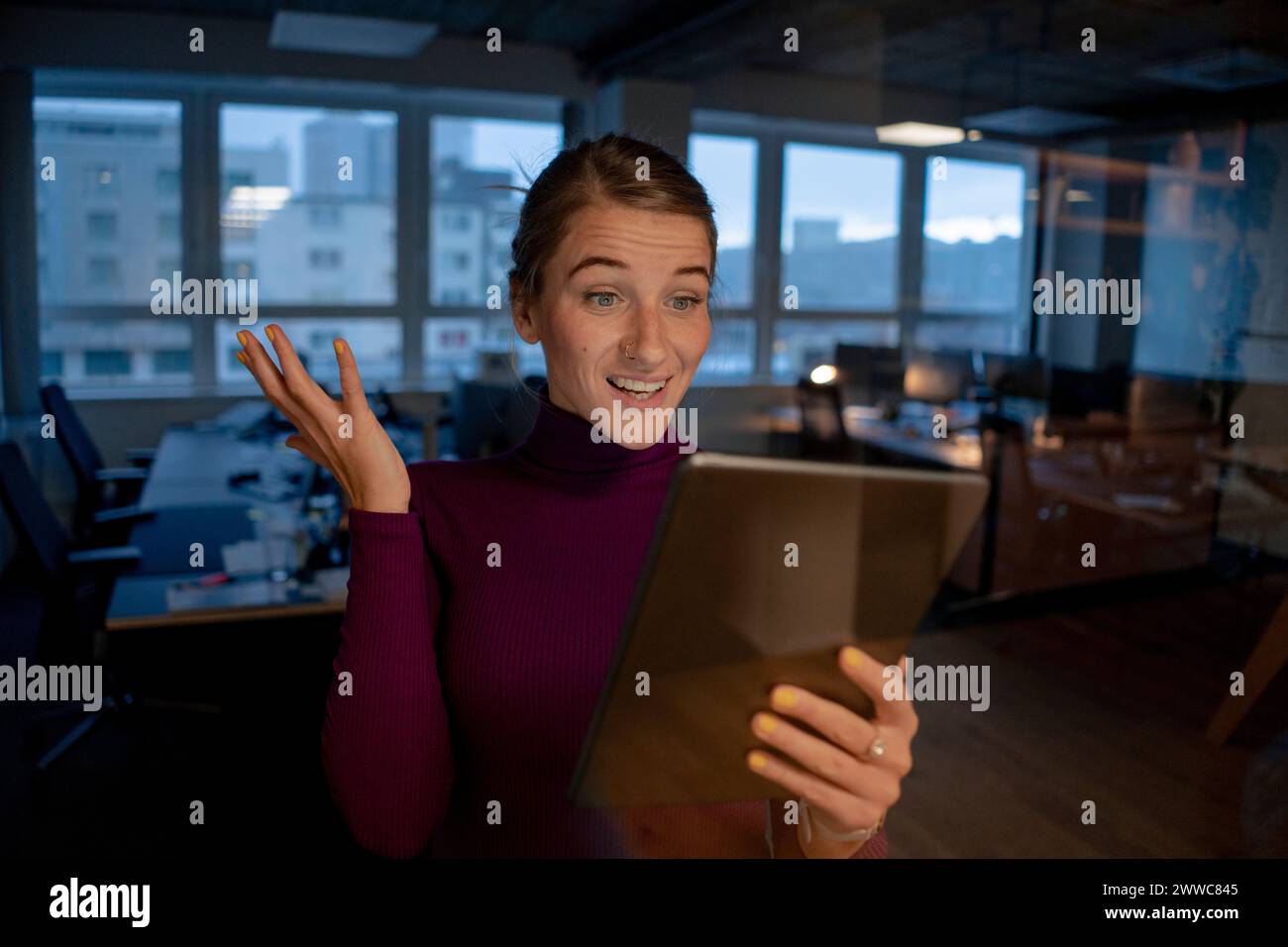 Femme d'affaires surprise parlant sur l'appel vidéo via tablette PC dans le bureau Banque D'Images