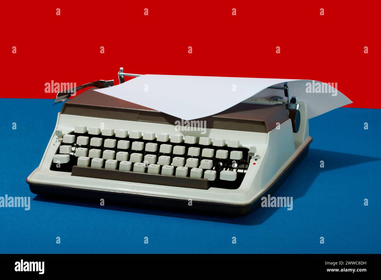 Machine à écrire rétro avec du papier sur fond coloré Banque D'Images
