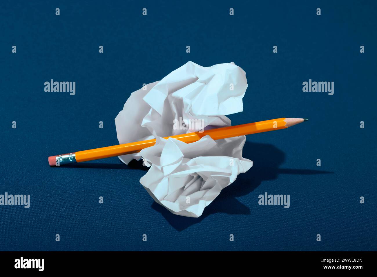 Papier froissé avec un crayon sur fond bleu Banque D'Images