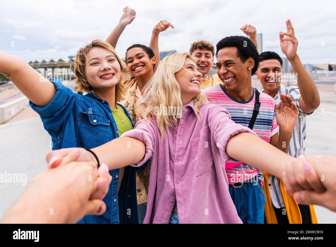 Heureux jeunes amis se tenant la main et s'amusant ensemble Banque D'Images