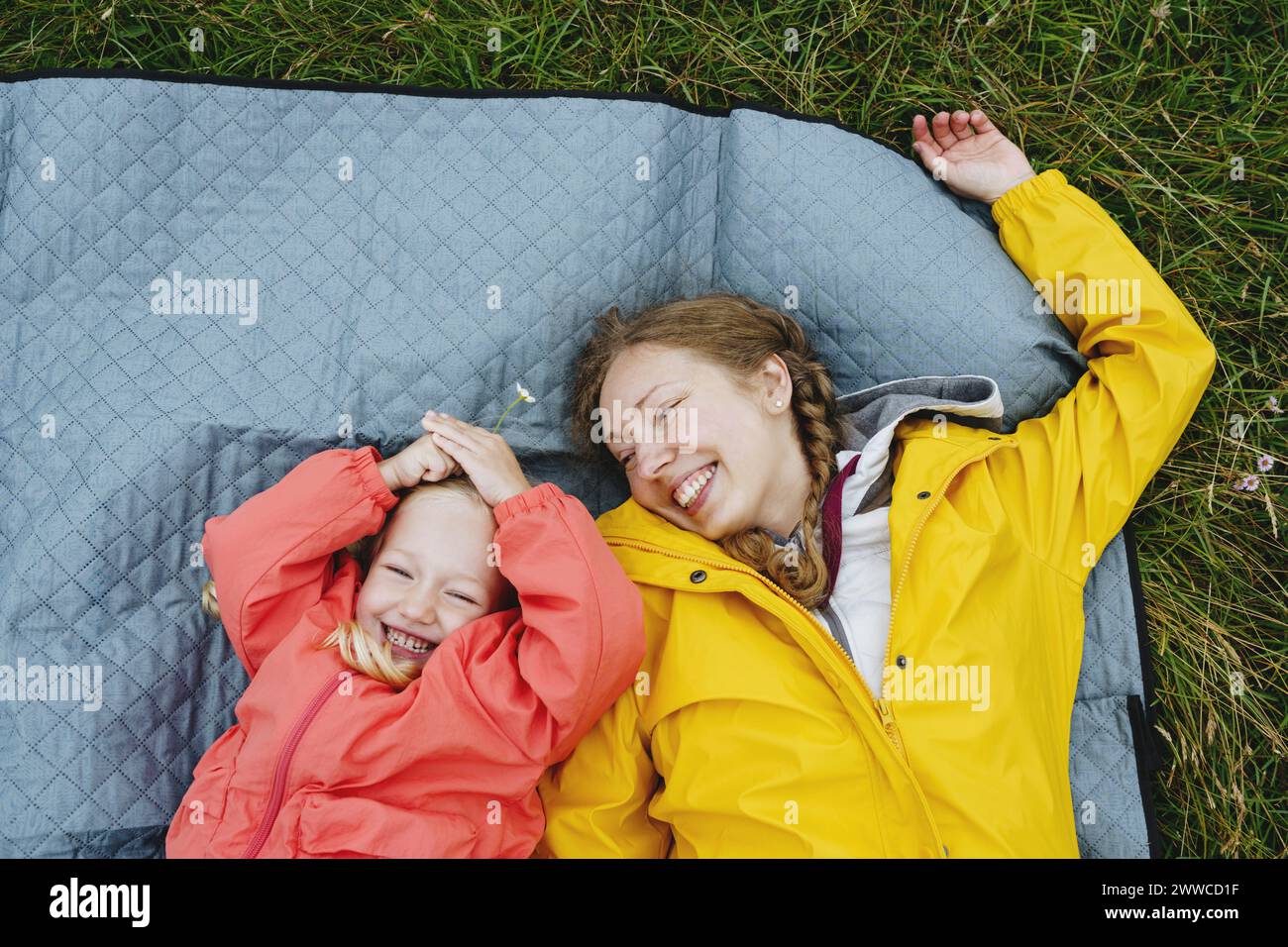 Heureuse mère et fille allongées sur une couverture de pique-nique Banque D'Images