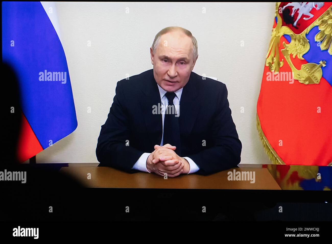 Vue du président russe Vladimir Poutine photo sur un écran de télévision lorsqu'il s'adresse aux citoyens du pays dans le cadre de l'attaque terroriste à la mairie de Crocus. Dans la soirée du 22 mars, des inconnus camouflés, armés de mitrailleuses, conduisant dans une voiture Renault blanche, ont attaqué le bâtiment de la salle de concert de la mairie de Crocus à Moscou, au moment où le concert du groupe de pique-nique a commencé là-bas. Les militants sont entrés dans le bâtiment et ont commencé à tirer sur tous ceux qui se mettaient sur leur chemin. Selon les données les plus récentes, quatre terroristes présumés auraient été détenus Banque D'Images