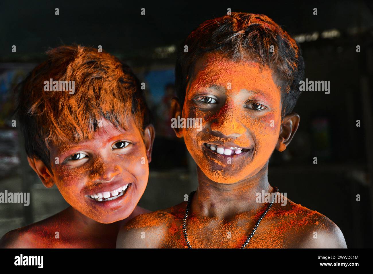Deux enfants du village rural colorent leur propre visage pendant le temps Holi, couleur de la vie à Sundarban Island, au Bengale occidental, en Inde. Banque D'Images