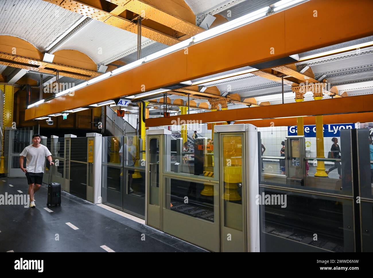 Paris, France, 30 juin 2022. Tourné à la station de métro Gare de Lyon, l’utilisation généralisée de la couleur jaune est frappante. Les gens marchent le long du quai. Banque D'Images