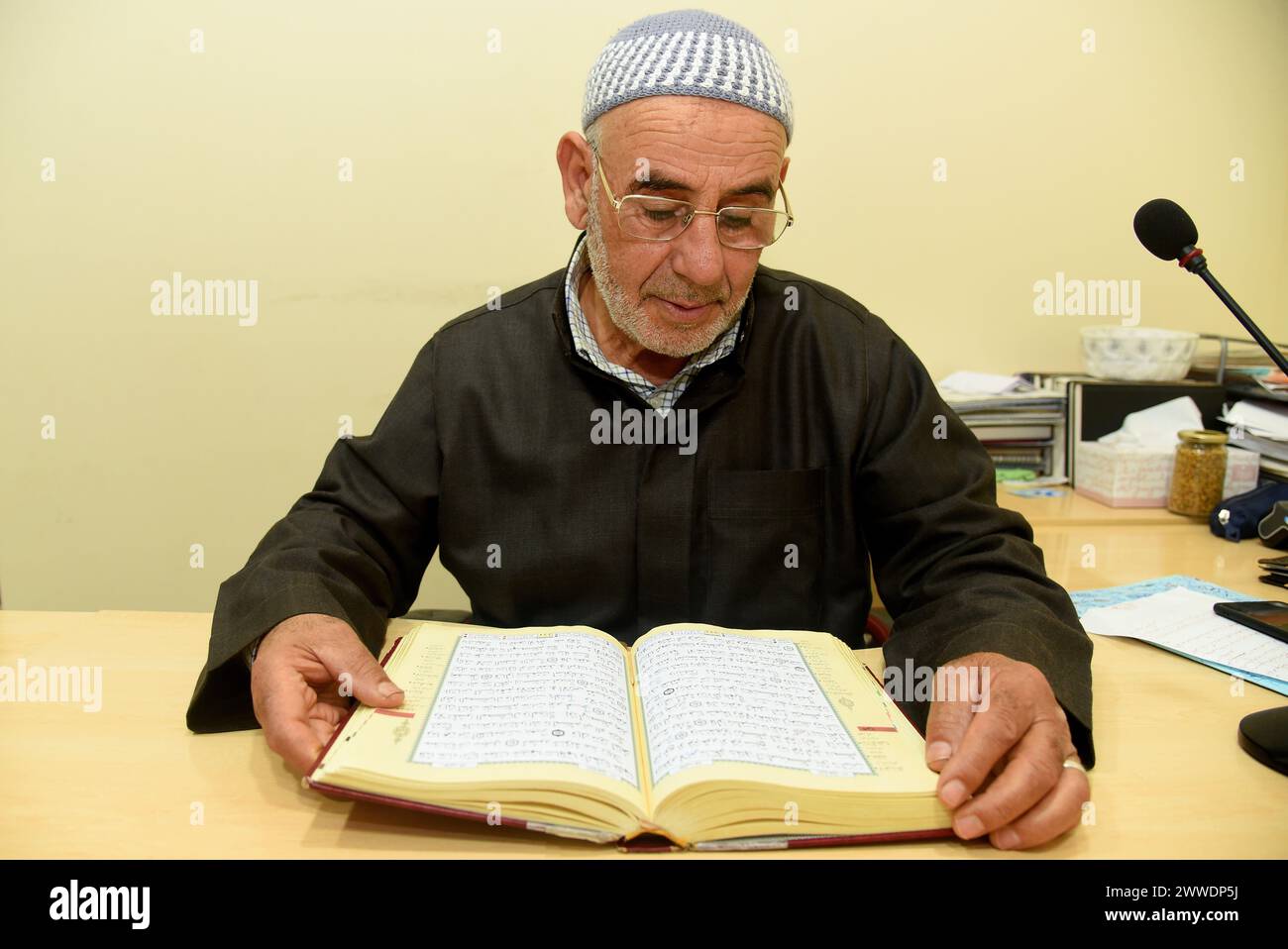 Le directeur de la mosquée islamique de Vendrell Hassan Smini lit des chapitres du Livre Saint du Coran pendant le Ramadan avant la prière de la cinquième nuit. La communauté musulmane d'El Vendrell célèbre le Ramadan et leur rassemblement à la mosquée islamique de la ville pour effectuer la prière de nuit appelée 'Isha'. Dans Vendrell il y a environ 2 600 personnes enregistrées de différentes nationalités et leur religion est l'Islam, outre les fils et les filles de ces immigrés déjà nés en Espagne, où il y a environ 3 000 musulmans dans une ville d'environ 39 000 habitants. Avant de prier, les hommes se lavent les mains, m Banque D'Images