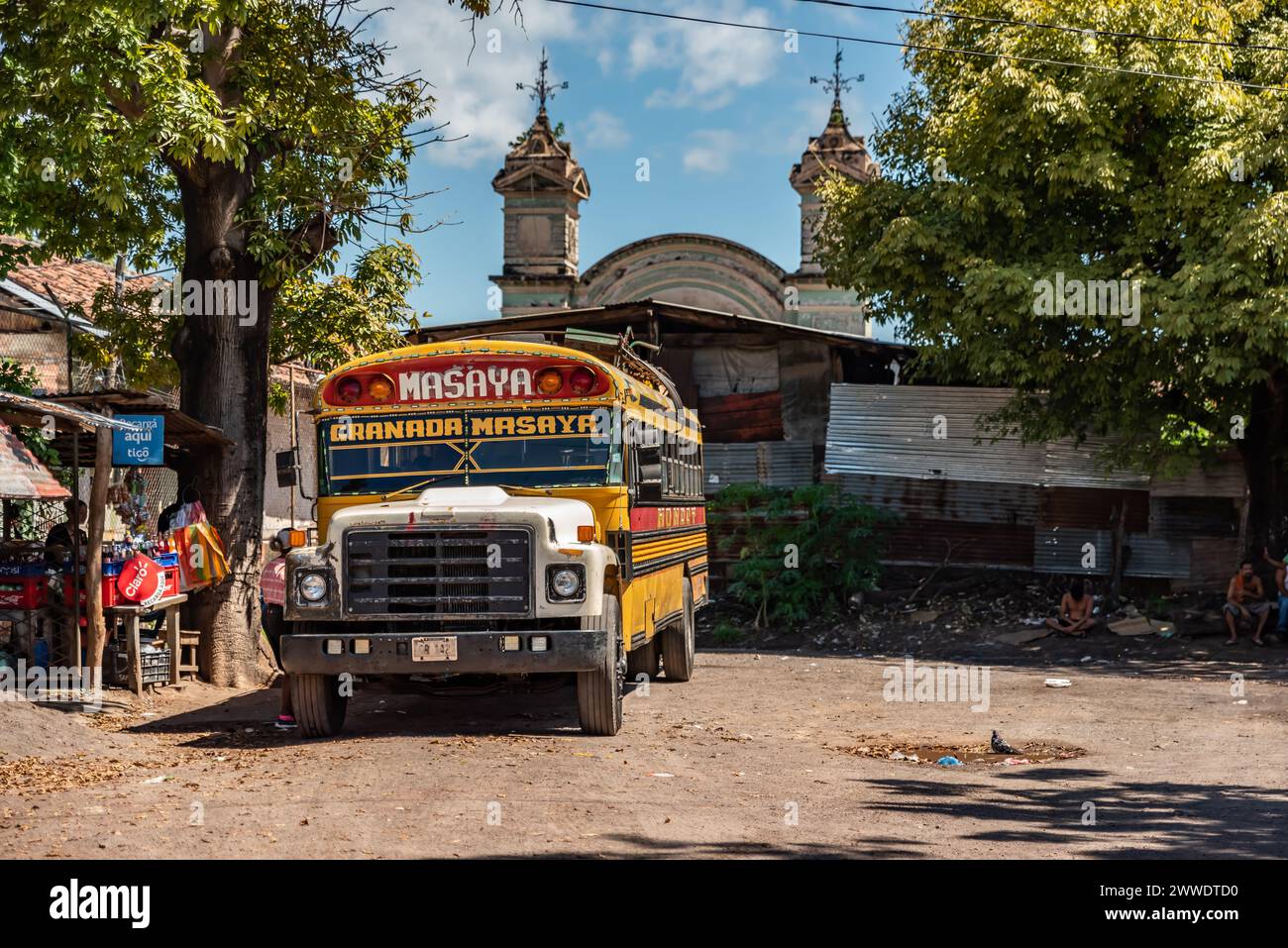 Un bus coloré à poulets avec un panneau de route Masaya-Granada garé dans une ville du Nicaragua Banque D'Images