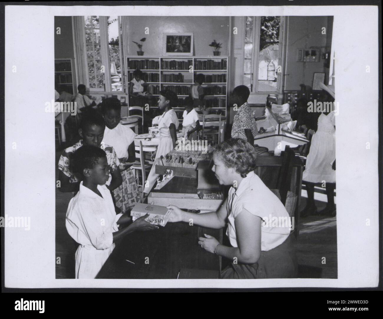 Section pour mineurs de la Bibliothèque publique de Bridgetown (Barbade), présentant un espace de lecture, des étagères et un environnement éducatif pour les enfants en mars 1955. Banque D'Images