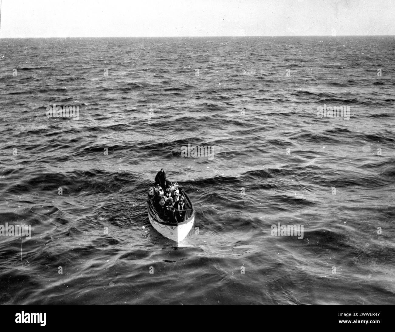 Photographie montrant le canot de sauvetage No.6 du RMS Titanic approchant du navire de sauvetage Carpathia le 15 avril 1912. Prise peu après le naufrage du navire dans l’Atlantique Nord, l’image documente l’opération de sauvetage qui a suivi la catastrophe maritime. Banque D'Images