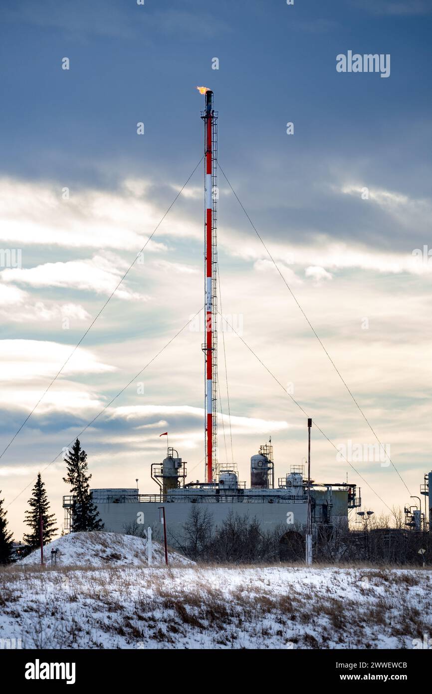 Cochrane Alberta Canada, 06 février 2024 : torchère avec flamme dans une usine de gaz pendant l'hiver pendant la vue portrait hivernale. Banque D'Images
