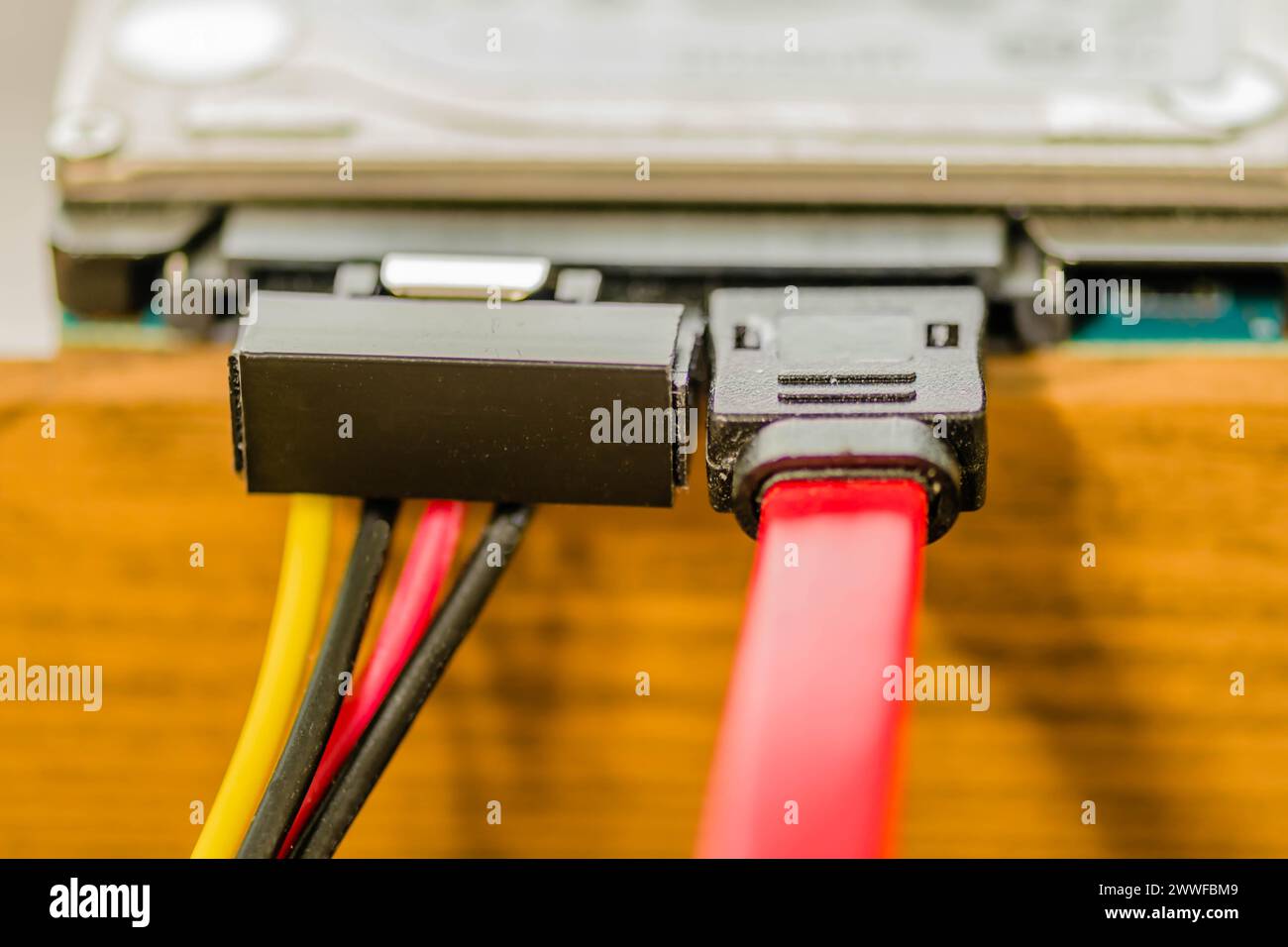 Gros plan du câble sata branché sur le disque dur de l'ordinateur sur l'établi. Le câble gauche transfère l'alimentation, le câble droit transfère les données Banque D'Images