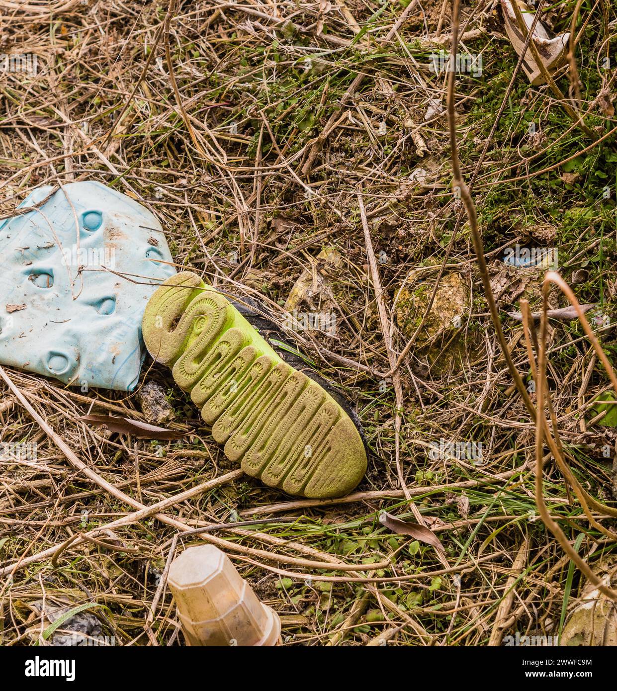 Chaussure jetée au milieu de la litière en plastique sur le sol, montrant des dommages environnementaux, en Corée du Sud Banque D'Images