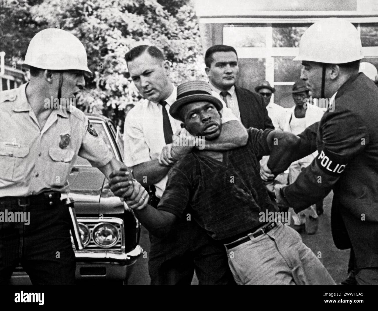 Atlanta, Géorgie 1966 policiers et détectives en civil traînant un manifestant noir vers un chariot rideau en attente lors d'une émeute qui a éclaté à Atlanta en 1966. Banque D'Images
