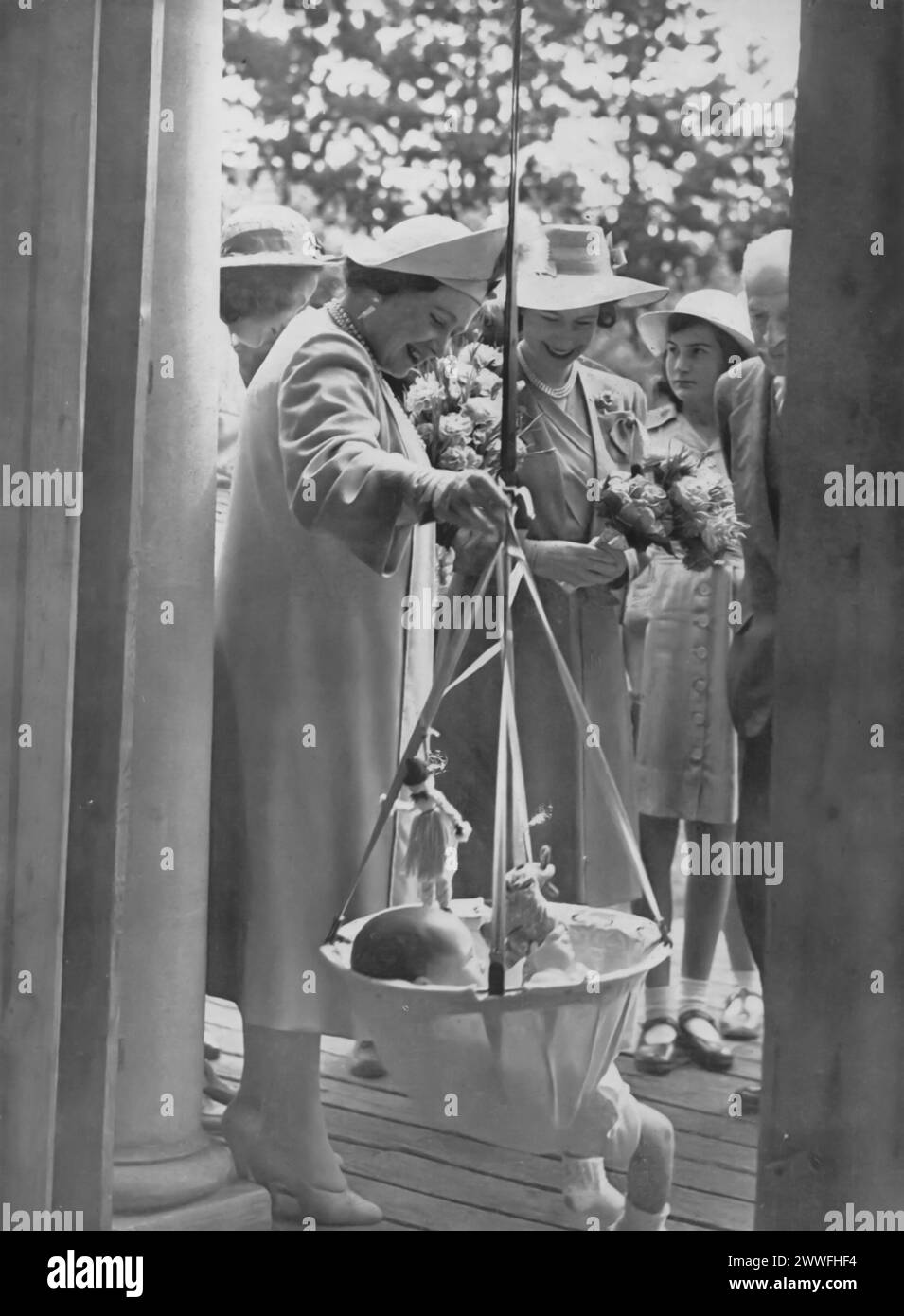 Une photographie de 1945 montre la reine Elizabeth I (la reine mère) et la princesse Elizabeth II visitant une école pour enfants handicapés. Cette visite témoigne du dévouement de la famille royale à l'égard du bien-être social et de son soutien aux groupes vulnérables dans la période d'après-guerre. Banque D'Images