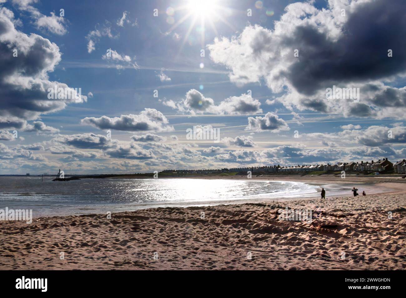 Regarder dans le soleil sur la mer et la plage avec le couple art par andrew Newbiggin by Sea, Northumberland, Angleterre royaume-uni Banque D'Images