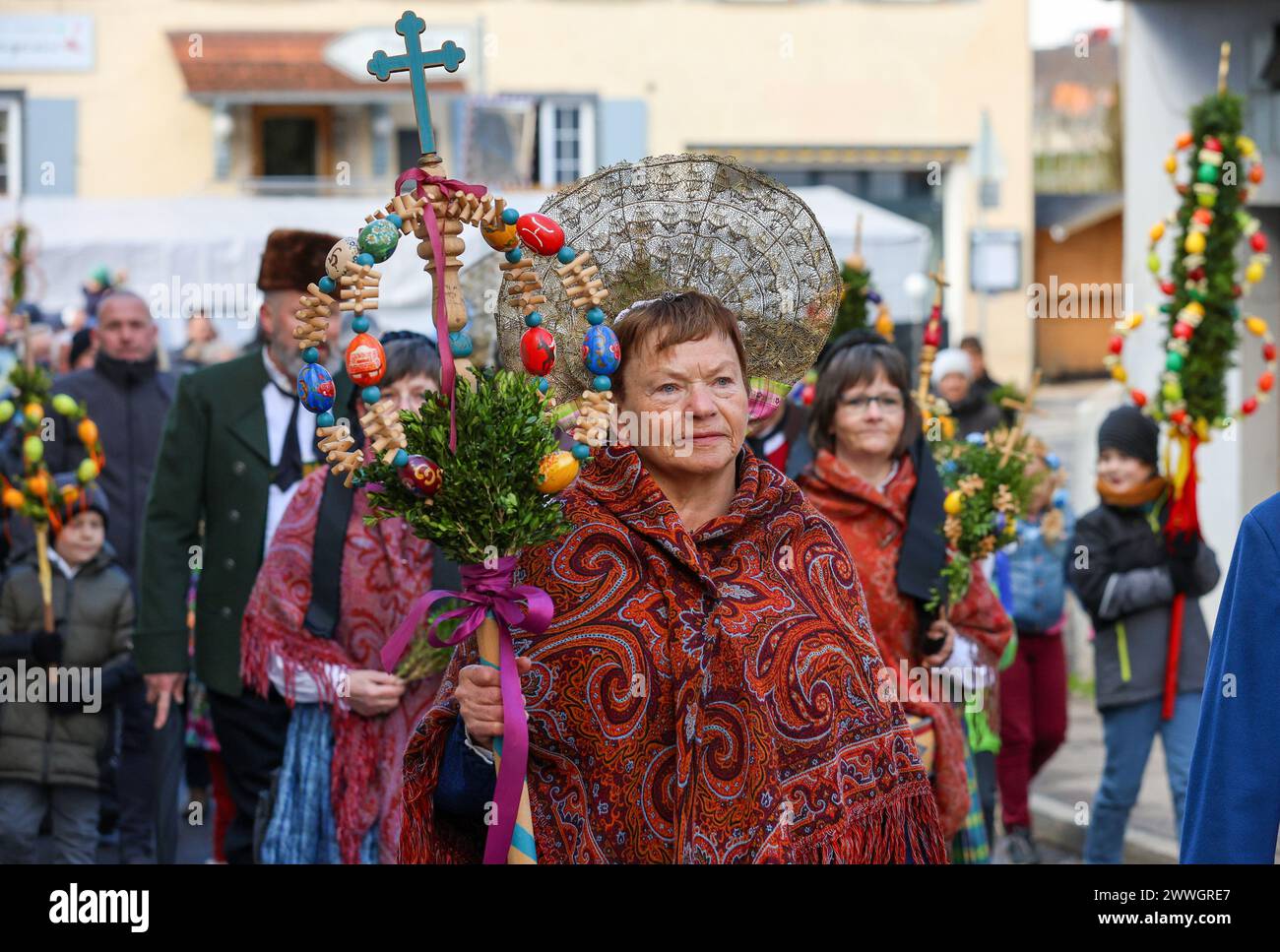 Riedingen, Allemagne. 24 mars 2024. Les femmes et les hommes de la guilde traditionnelle des costumes portent un «palmier» dans les rues de la vieille ville lors de la procession du dimanche des Rameaux. Les fidèles commémorent alors l'entrée de Jésus à Jérusalem. Ses disciples auraient acclamé Christ et jeté des branches de palmier sur son chemin. Crédit : Thomas Warnack/dpa/Alamy Live News Banque D'Images