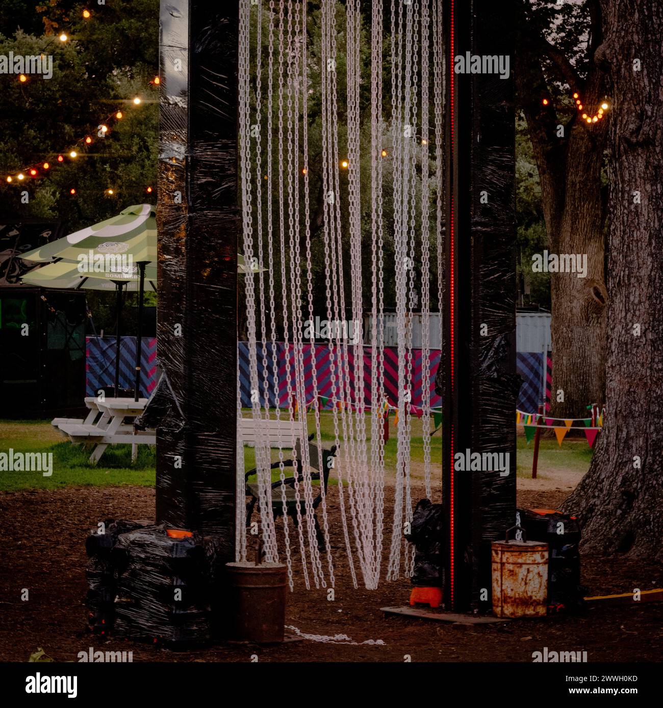 Les lumières du soir scintillent lors d'un festival en plein air avec des sièges et une grande roue en vue. Banque D'Images