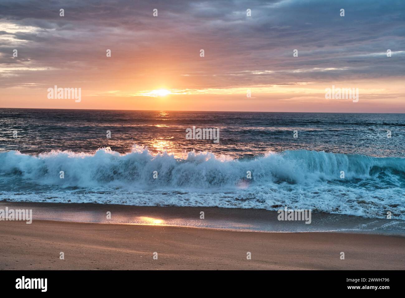 Vagues de l'océan altlantique écrasant sur la plage de la côte d'argent en France avec coucher de soleil doré en arrière-plan, Cap Ferret, Aquitaine, Fran Banque D'Images