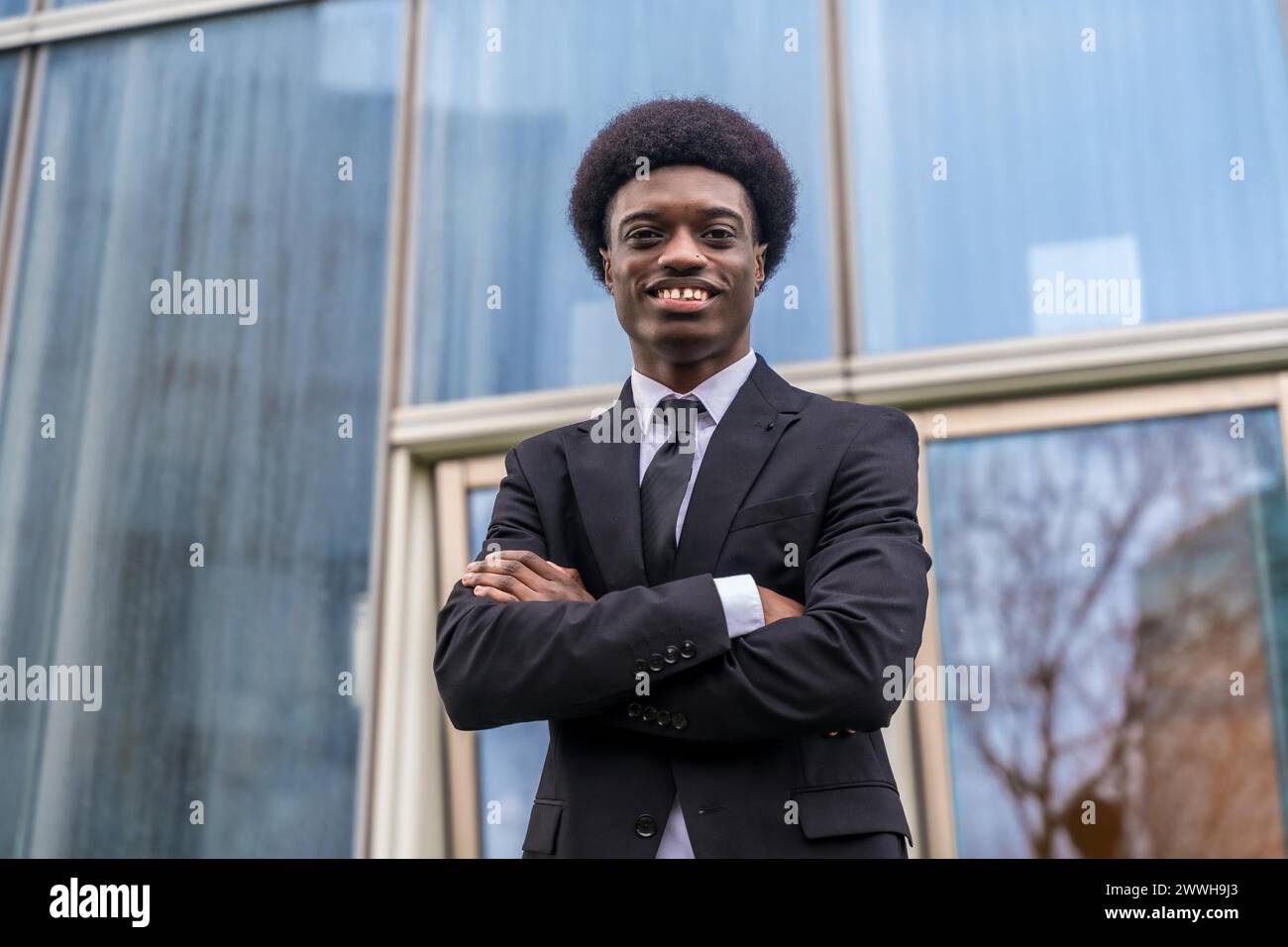 Portrait d'un jeune et fier homme d'affaires africain debout devant un bâtiment financier Banque D'Images