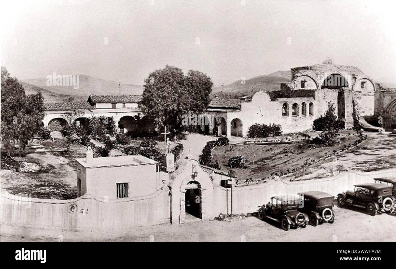 https://en.wikipedia.org/wiki/Mission San Juan Capistrano#/media/File:Mission San Juan Capistrano circa 1921.jpg::text=This%201921%20view%20of%20the%20Mission%20San%20Juan%20Capistrano%20complex%20documents%20the%20restoration%20work%20that%20was%20already%20well%20underway%20by%20that%20time.%20The%20perimeter%20garden%20wall%20(including%20the%20ornate%20entranceway)%20and%20adjacent%20outbuilding%20are%201917%20additions. Banque D'Images