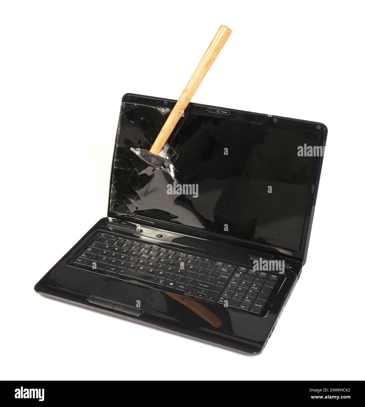 Vieil ordinateur portable cassé isolé sur fond blanc, cassé avec un marteau Banque D'Images