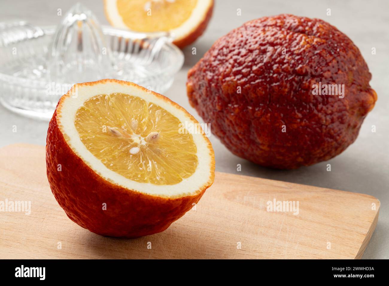 Entier et coupé en deux citrus limon frais Rosso, citron rouge, gros plan sur une planche à découper Banque D'Images
