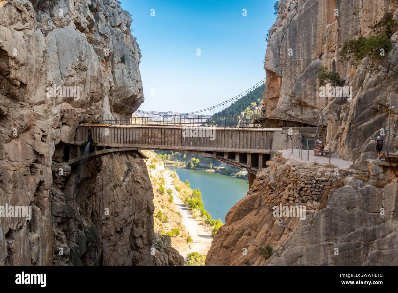 Promenade El Caminito del Rey le long des parois escarpées d'une gorge étroite à El Chorro avec spectaculaire vieux pont de pierre se rejoignant, Espagne Banque D'Images