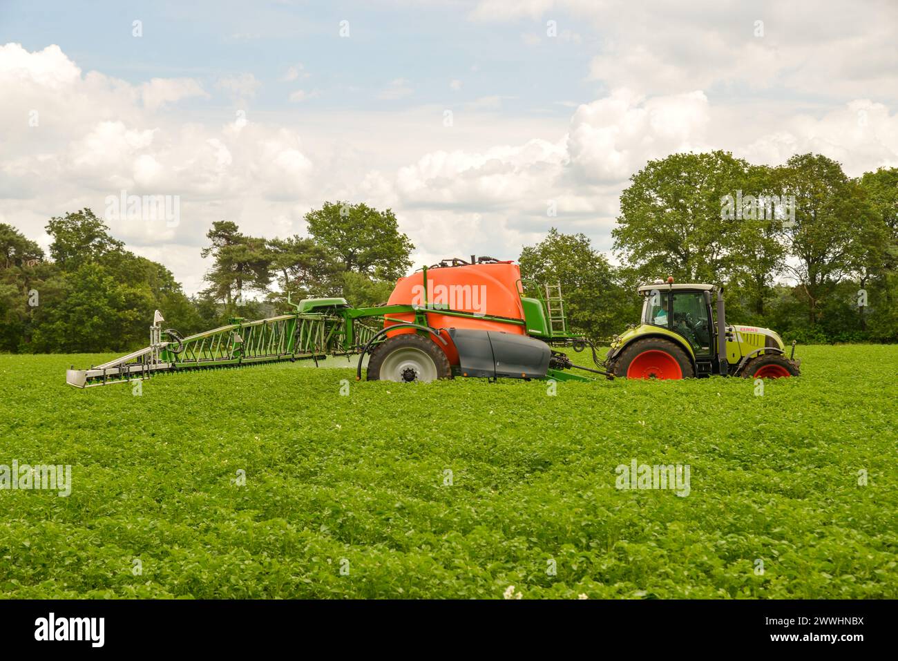 tracteur pulvérisant l'herbicide sur les terres agricoles Banque D'Images