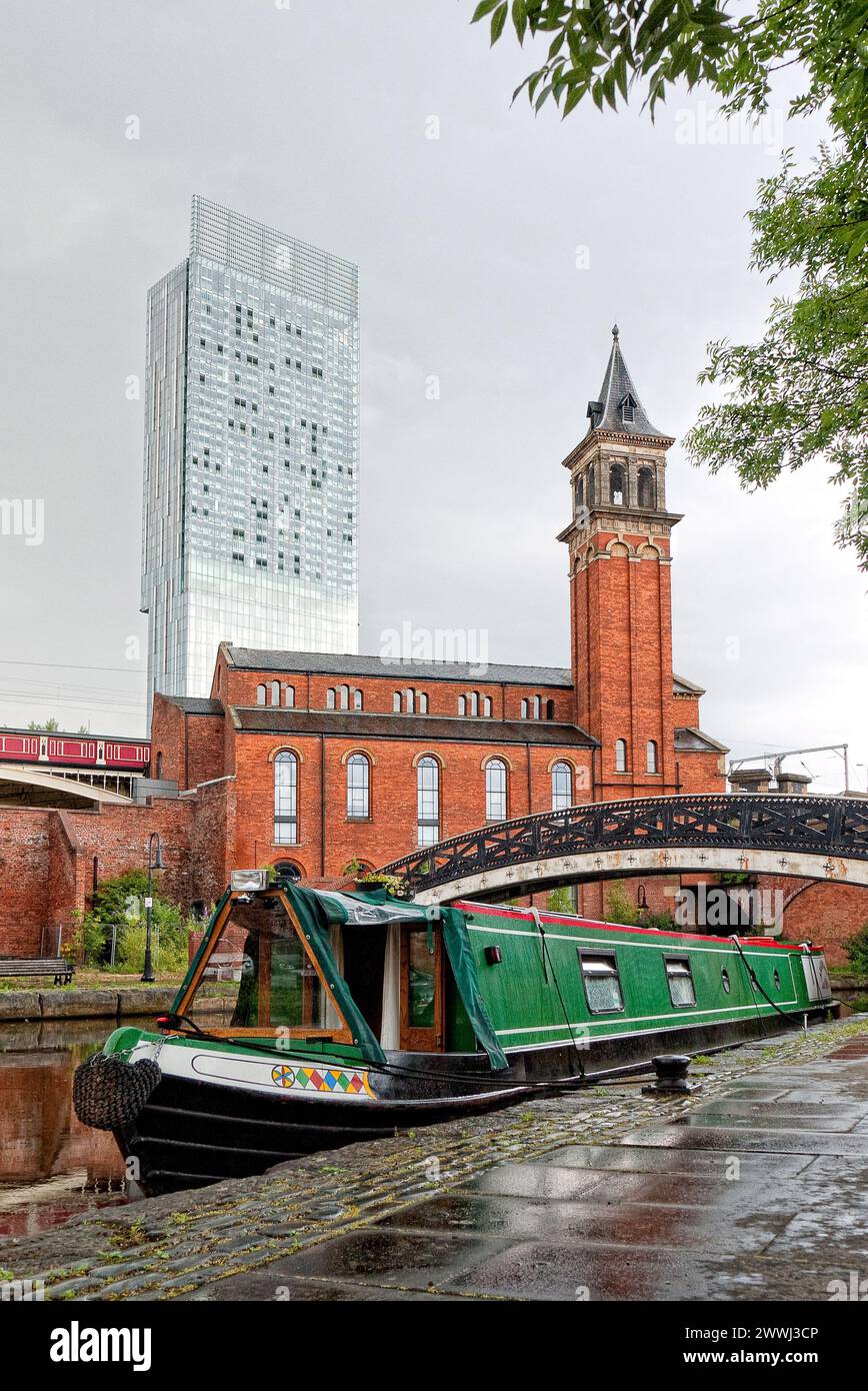 Bateau étroit aux couleurs vives amarré à Castlefield Basin sur le canal Bridgewater avec la Beetham Tower à Manchester, Angleterre, Royaume-Uni, Grande-Bretagne Banque D'Images