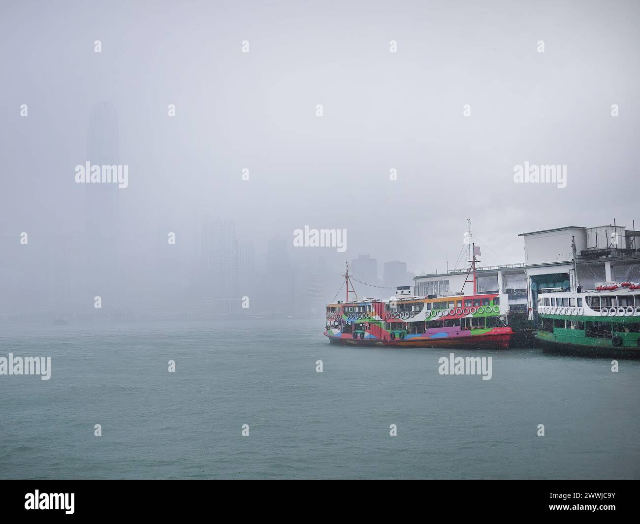 Un transport en ferry sous de fortes pluies à Victoria Habour, Hong Kong, bateau-taxi coloré, bateau, célèbre ferry pour la vie quotidienne et le tourisme, gris RA Banque D'Images