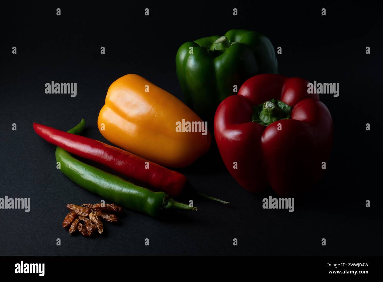 piment paprika coloré au poivre sur fond noir Banque D'Images