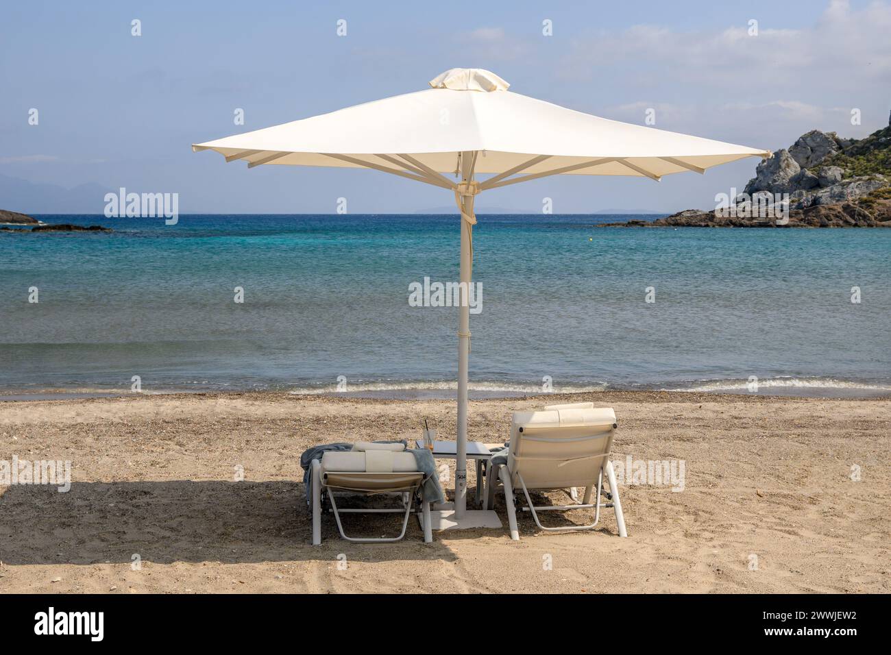 Chaises longues avec parasol sur la plage de sable d'Agios Stefanos. L'île grecque de Kos Banque D'Images