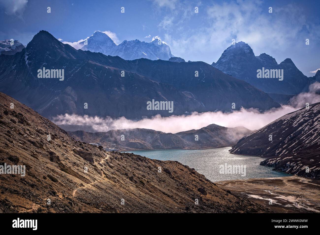 Un sentier traverse la base de Gokyo Ri sur le chemin de Gokyo comme Mt. L'Everest s'élève en arrière-plan dans le parc national de Sagarmatha, au Népal. Banque D'Images