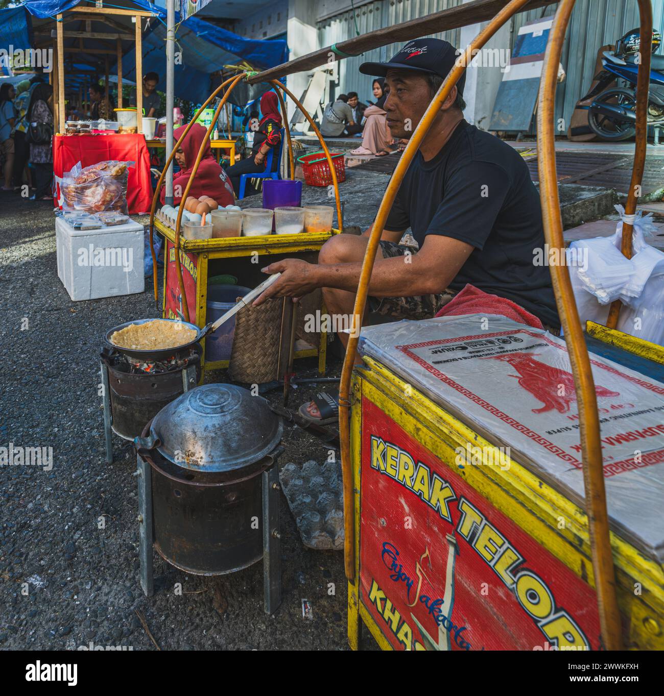 Balikpapan, Indonésie - 22 mars 2024. Il vend Kerak Telor snack au marché du Ramadan. Banque D'Images