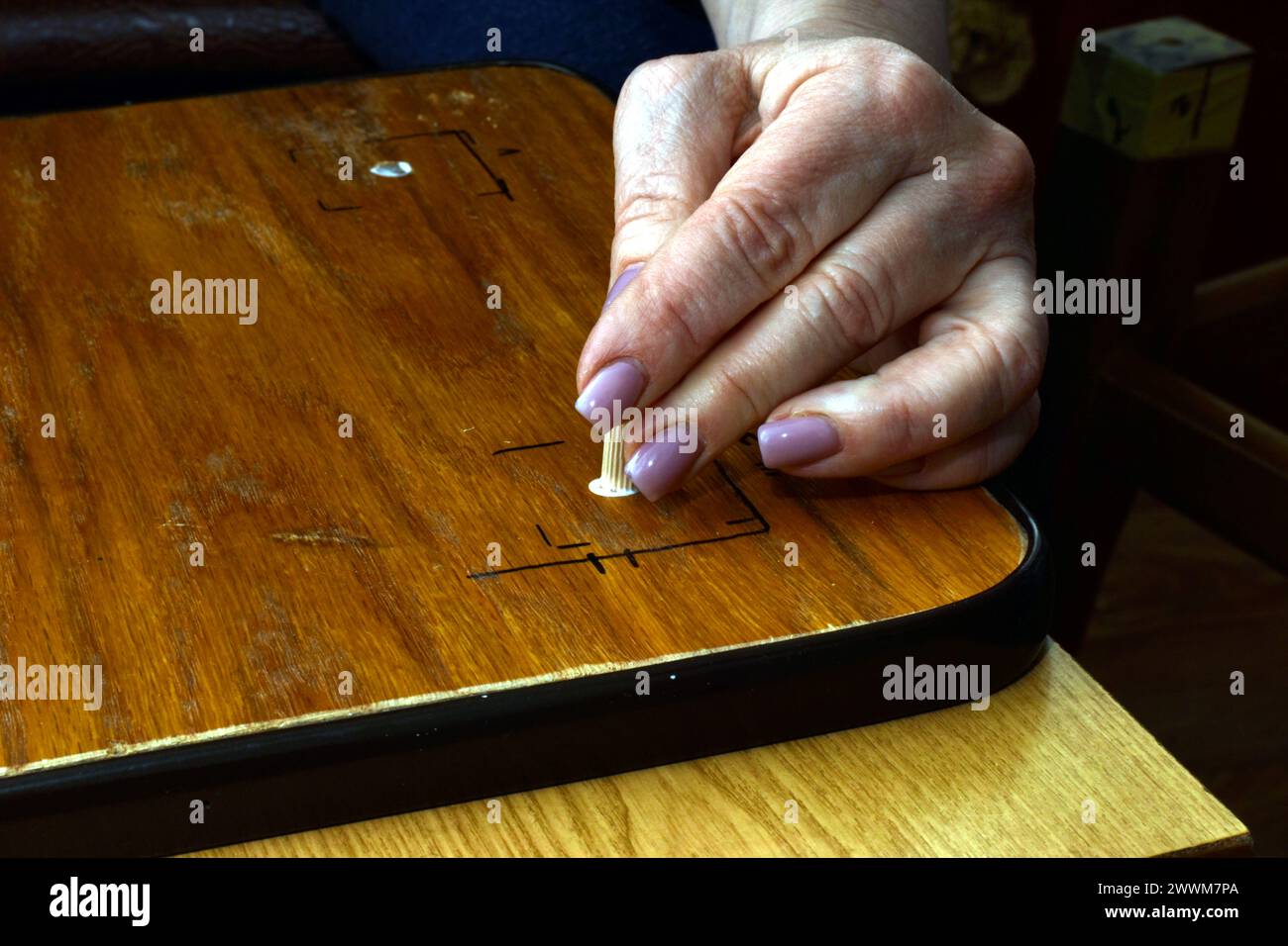 L'image montre le moment d'insérer une cheville en bois dans le trou dans le siège de la chaise. Banque D'Images